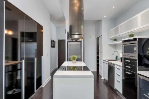 a kitchen with white cabinets and a white counter top at Glamorous City Escape King Bed & CN Tower Views in Toronto