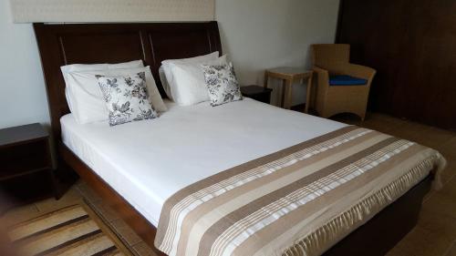 a bedroom with a large white bed with two pillows at Villa Kayola - Self Catering in Mahe