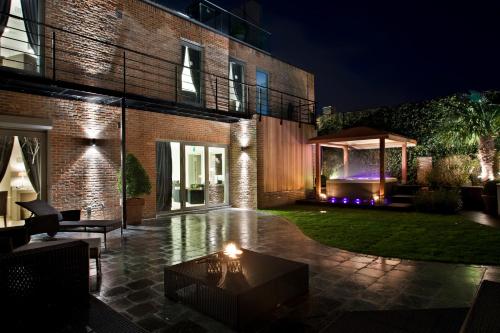 a house with a courtyard at night with a gazebo at Tuinhotel in Lommel