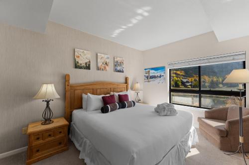 Un dormitorio con una cama y un sofá y una ventana. en Greens at Copper 217 by Summit County Mountain Retreats, en Copper Mountain