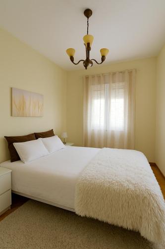 a bedroom with a large white bed and a window at Casa da Boavista in Amarante