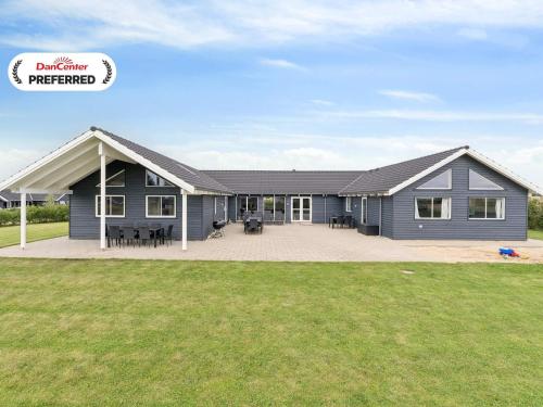 a large blue house with a large patio at Luxury Retreat by Hostrup Beach - By Traum Ferienwohnungen in Spottrup