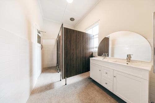 a bathroom with a sink and a mirror at Strathfield Hotel in Sydney