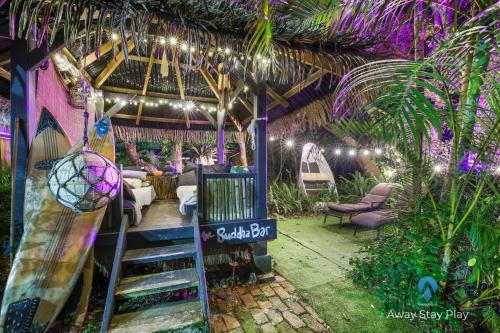 a room with a surfboard and a table and chairs at Shellies Twin Beach Houses in Sawtell