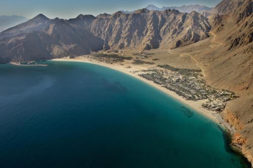 an aerial view of a beach in the middle of a mountain at Six Senses Zighy Bay in Dibba