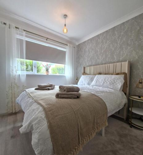 a bedroom with a bed with towels on it at Home on the Broads Just Renovated in Lowestoft