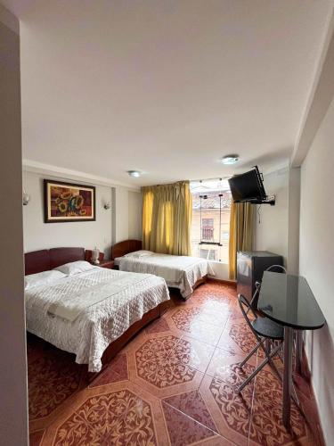 a hotel room with two beds and a television at Retamas Hotel in Cajamarca
