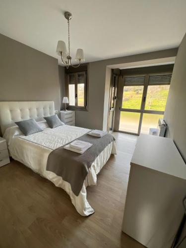 a bedroom with a large bed and a table at Casa nueva con jardín y wifi en Ribeira Sacra in Castrelo