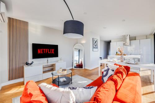 a living room with a couch and a tv at Stunning Penthouse in City Centre with Free Parking, Balcony, Aircon, Self Check-In, Fast WiFi and Sky TV by Yoko Property in Milton Keynes