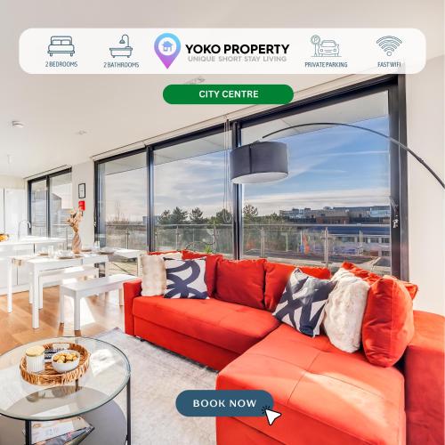 a red couch in a living room with a large window at Stunning Penthouse in City Centre with Free Parking, Balcony, Aircon, Self Check-In, Fast WiFi and Sky TV by Yoko Property in Milton Keynes