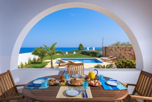 a table with food and a view of the ocean at Villa Deep Blue in Lachania