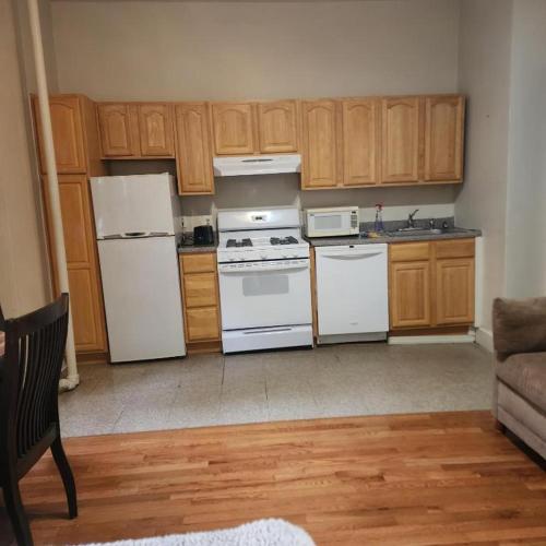 a kitchen with white appliances and wooden cabinets at New York City Guest House in New York