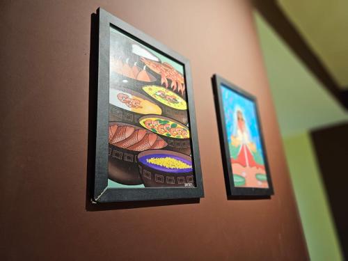 two framed pictures of food on a wall at Praculá Hotel in Belém