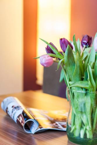 a vase filled with purple tulips sitting on a table at Hotel Fauna in Breiholz