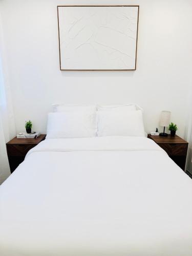 a bedroom with a white bed with a picture on the wall at Modern 2BR Guest Suite with Kitchen, Free Parking, Fire Pit - 10 mins to SJC in San Jose