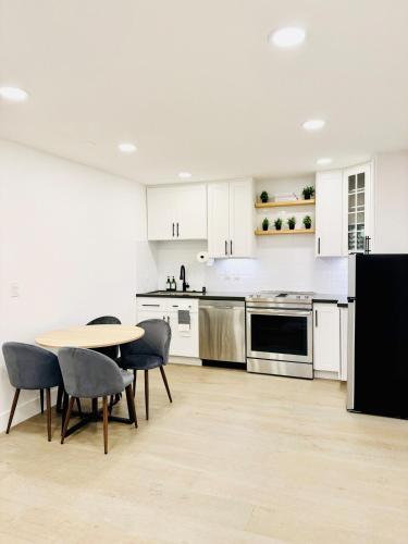 a kitchen with white cabinets and a table and chairs at Modern 2BR Guest Suite with Kitchen, Free Parking, Fire Pit - 10 mins to SJC in San Jose