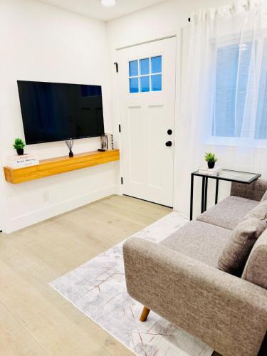 a living room with a couch and a flat screen tv at Modern 2BR Guest Suite with Kitchen, Free Parking, Fire Pit - 10 mins to SJC in San Jose