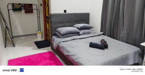 a bedroom with a large bed with a pink rug at ZZD Gunong Roomstay in Bachok