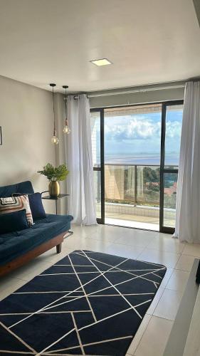 a living room with a blue couch and a large window at 1209 Studio with Panoramic Sea View in São Luís