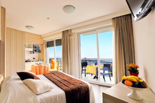 a hotel room with a bed and a large window at Excelsior Hotel E Appartamenti in Loano