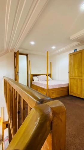 a bedroom with a bed and a wooden railing at Villa Magnifique in Abomey-Calavi
