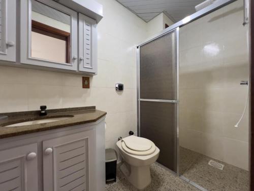 um banheiro com vaso sanitário, pia e chuveiro em Pé na areia em Capão da Canoa