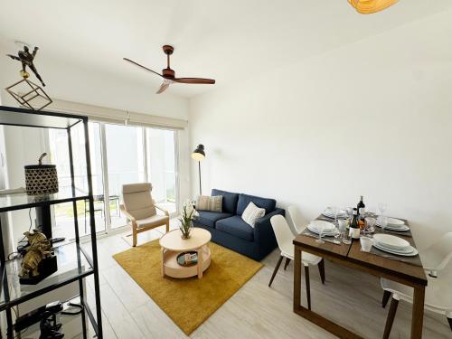 a living room with a blue couch and a table at 1 Bedroom Apartment with spectacular pool and golf course view in Punta Cana