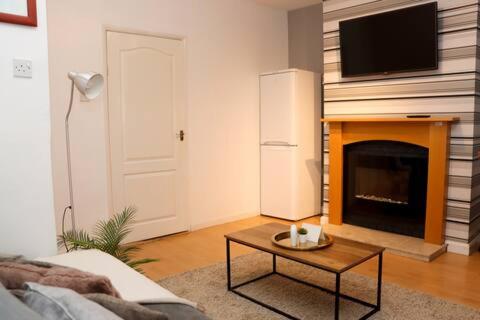 a living room with a fireplace with a tv above it at Entire 3 Bedroom Home Rotherham in Rawmarsh