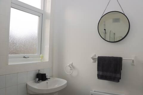 a white bathroom with a sink and a mirror at Entire 3 Bedroom Home Rotherham in Rawmarsh