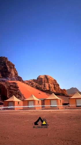 millennium camp في وادي رم: مبنى في الصحراء مع جبال في الخلفية
