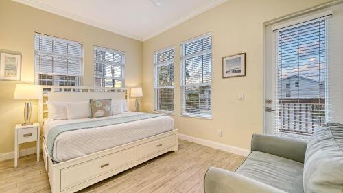 Un dormitorio con una cama y un sofá y ventanas. en Casa Junonia - 1032L, en Siesta Key