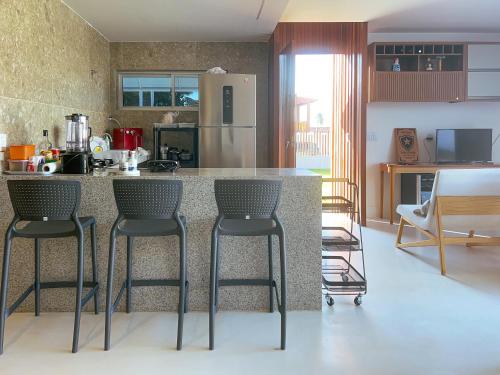 una cucina con 2 sgabelli da bar e piano di lavoro di Casa de Verão - Praia de Muriú a Muriú
