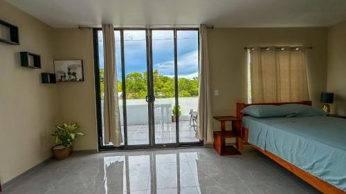 a bedroom with a bed and a large sliding glass door at Olas del alba in Tapantí