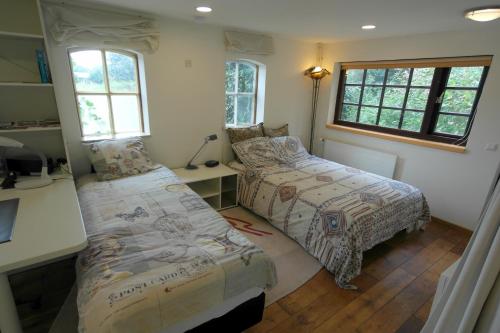 a bedroom with two beds and a desk and windows at Art, Bed & Breakfast in Velden