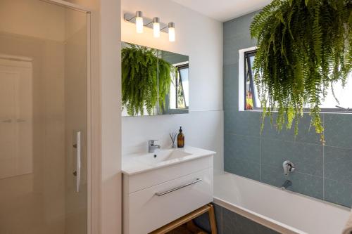 a bathroom with a sink and a mirror at Te Makiri House, Onetangi - Be My Guest Waiheke in Waiheke Island
