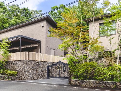 a house with a gate in front of it at Glamdy style hotel suite 山ノ麓 in Karuizawa