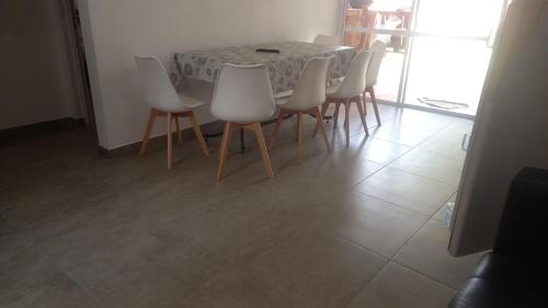 Un comedor con una mesa y sillas blancas. en Quinta in Sauce Viejo, aire libre, 