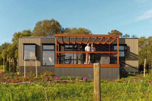 two people standing on the balcony of a house at AUTRA Resort Lyndoch in Lyndoch