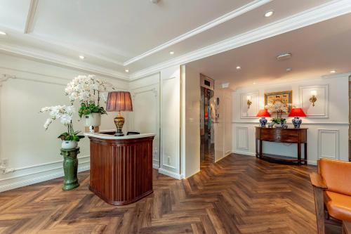 een lobby met een bureau en een tafel met bloemen bij Ngan Ha 2 Apartment in Ho Chi Minh-stad