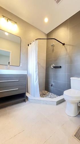 a bathroom with a shower and a toilet and a sink at Yonge Finch Subway Modern Suite with En Suite Bathroom in Toronto