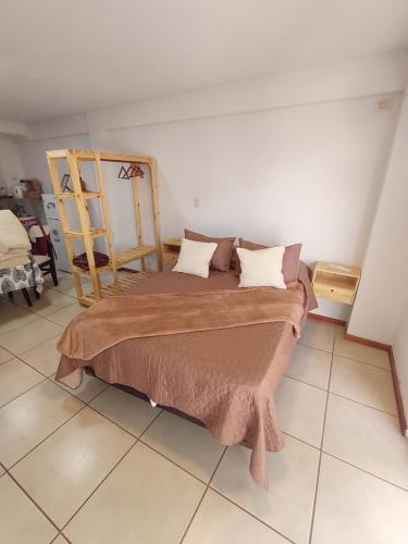 a bedroom with a large bed and a chair at Monoambiente Montevideo in Rosario