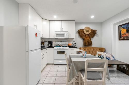 バンクーバーにあるSpacious 3BR with Full Kitchen a n dFast Wi-Fiのテーブルと白い冷蔵庫のあるキッチン