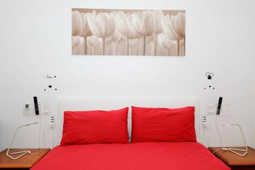 a bedroom with a red bed with two red pillows at Luxury Panoramic Apt w Garage Happy Home Bergamo 2 in Bergamo