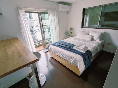 a bedroom with a large bed and a window at Han Homes Yokohama in Yokohama