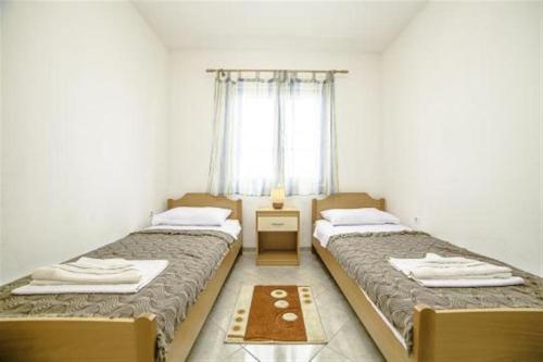 zwei Betten in einem kleinen Zimmer mit Fenster in der Unterkunft Family-friendly apartments with swimming pool Povlja, Brac - 24248 in Povlja