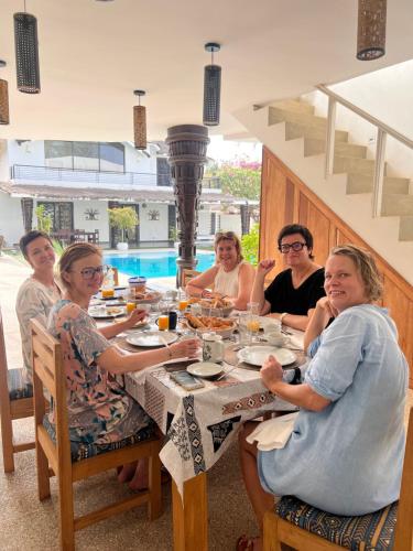 恩加帕鲁Au Paradis de Jeanne的一群人围坐在桌旁