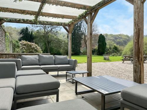 a patio with couches and a table and a pergola at Duvale Priory - 9985 in Bampton