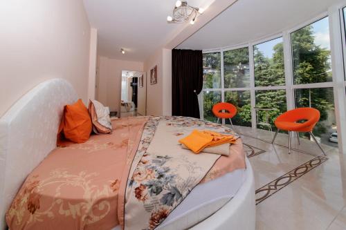 um quarto com uma cama grande e cadeiras laranja em Sandanski Peak Guest Rooms em Sandanski