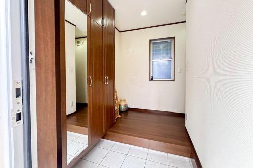 einen Flur mit Holztür in einem Zimmer in der Unterkunft アツギハウス Max 12 ppl Free parking 3story detached house in Osaka