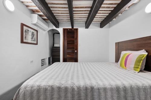 a bedroom with a white bed with a wooden ceiling at Old San Juan Art Loft Fast Wifi Near El Morro in San Juan